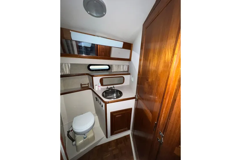 Slide: The Image of 1988 Carver 3807 Aft Cabin Motor Yacht bathroom with wood accents and compact design. - 16
