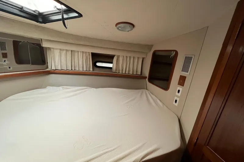 Slide: The Image of 1988 Carver 3807 Aft Cabin Motor Yacht interior cabin with bed and porthole. - 19