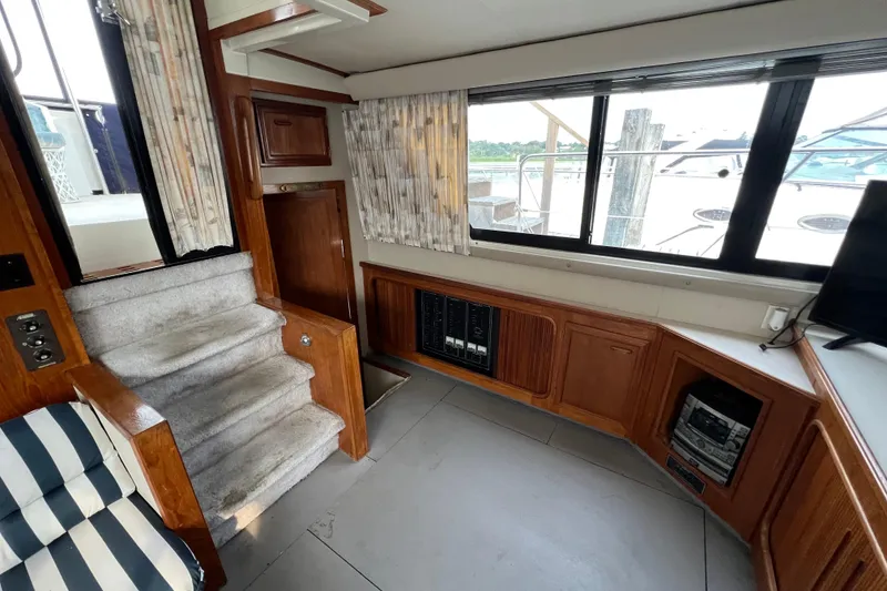 Slide: The Image of 1988 Carver 3807 Aft Cabin Motor Yacht interior with stairs, windows, and wood cabinetry. - 21