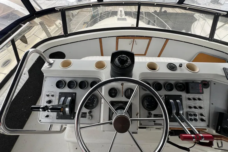 Slide: The Image of 1988 Carver 3807 Aft Cabin Motor Yacht helm with steering wheel and control panel. - 24