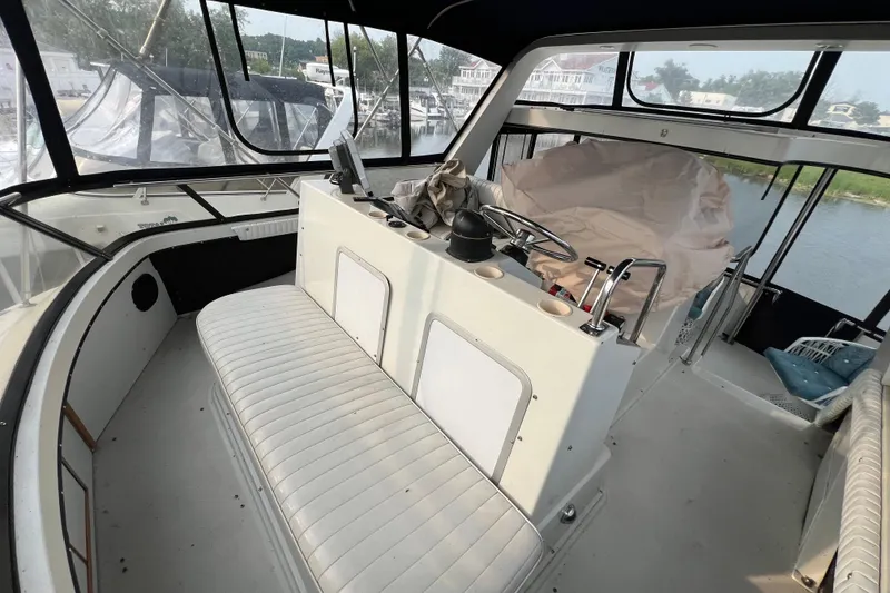Slide: The Image of 1988 Carver 3807 Aft Cabin Motor Yacht interior with helm and seating area. - 3
