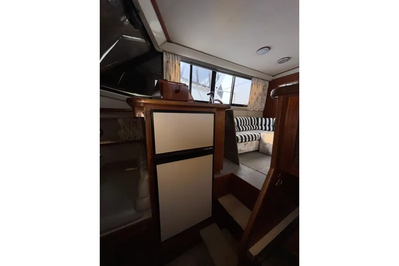 Slide: The Image of Interior of 1988 Carver 3807 Aft Cabin Motor Yacht with striped seating and compact kitchen. - 14