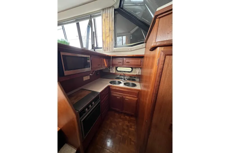Slide: The Image of 1988 Carver 3807 Aft Cabin Motor Yacht kitchen with wood cabinetry and modern appliances. - 18