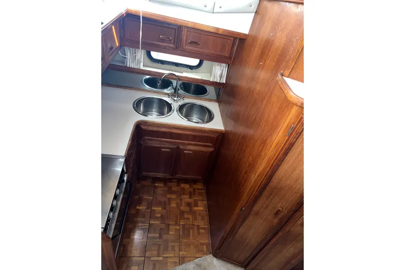 Slide: The Image of 1988 Carver 3807 Aft Cabin Motor Yacht kitchen with wood cabinetry and dual sinks. - 7