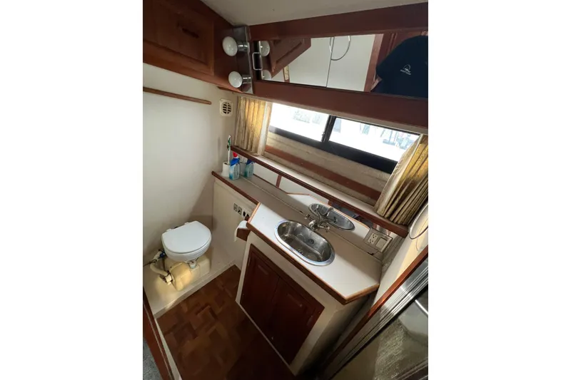 Slide: The Image of 1988 Carver 3807 Aft Cabin Motor Yacht bathroom with sink, toilet, and mirror. - 9