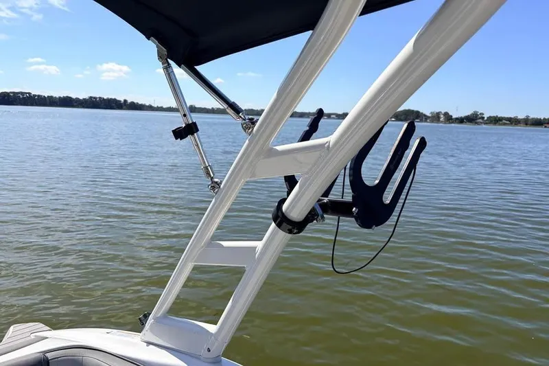 Slide: The Image of 2024 Yamaha Boats AR190 on calm lake with wakeboard rack. - 4