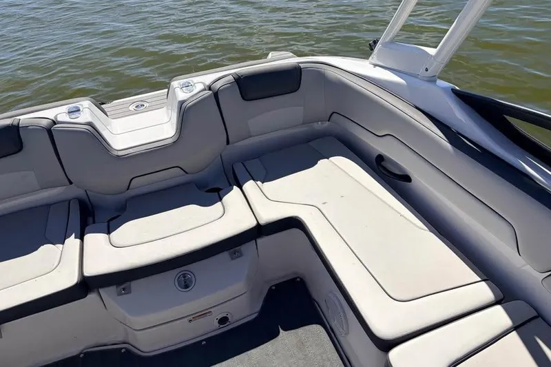 Slide: The Image of 2024 Yamaha Boats AR190 interior seating with cushioned layout on calm water. - 5