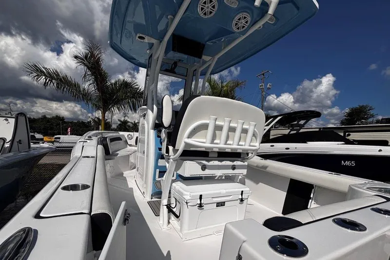 Slide: The Image of 2026 Tidewater 232 CC Adventure boat with seating and storage, under a partly cloudy sky. - 12