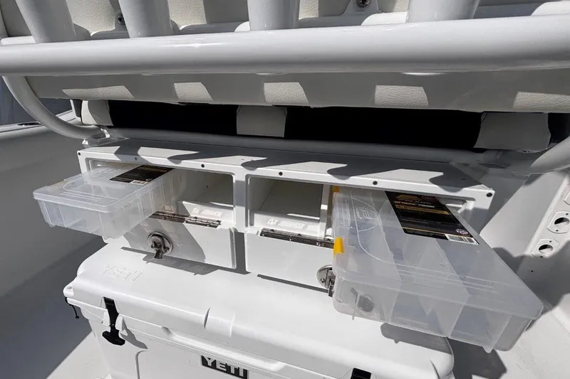 Slide: The Image of Tidewater 232 CC Adventure 2026 boat storage compartments with tackle boxes and Yeti cooler. - 15