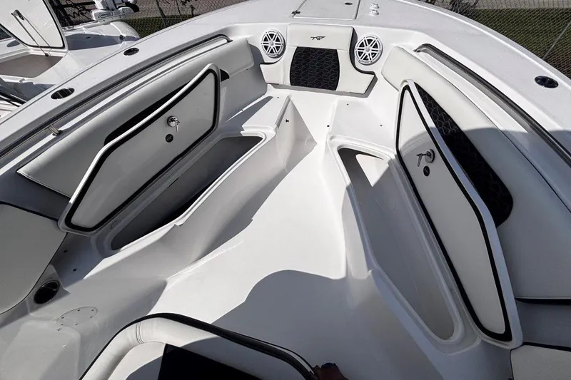 Slide: The Image of 2026 Tidewater 232 CC Adventure boat interior with open storage compartments and speakers. - 24