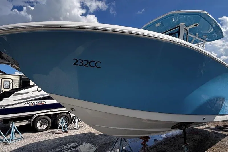 Slide: The Image of 2026 Tidewater 232 CC Adventure boat with blue hull under a clear sky. - 3