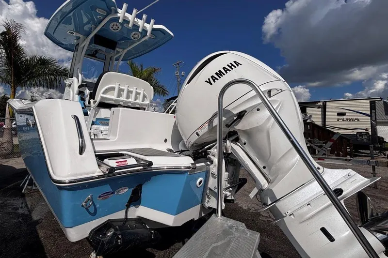 Slide: The Image of 2026 Tidewater 232 CC Adventure boat with Yamaha engine, docked under a cloudy sky. - 6