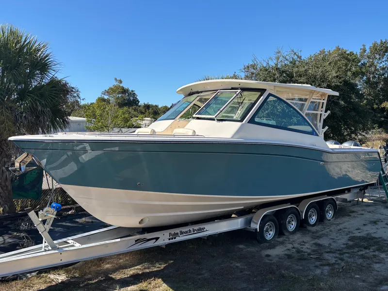 The Image of 2019 Grady-White Freedom 375 boat on trailer, parked outdoors under clear blue sky. - 0