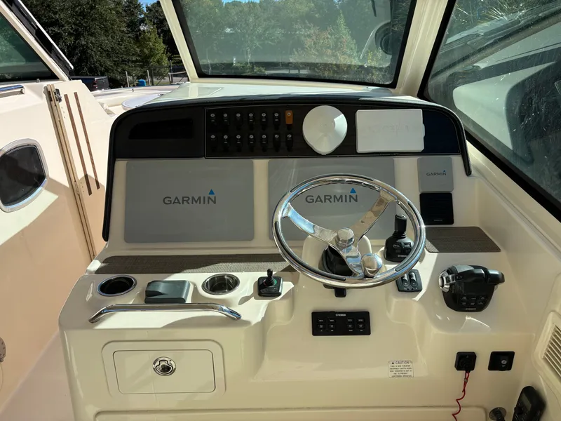 Slide: The Image of 2019 Grady-White Freedom 375 boat dashboard with Garmin navigation system and steering wheel. - 14