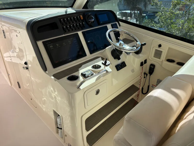 Slide: The Image of 2019 Grady-White Freedom 375 boat cockpit with steering wheel and control panel. - 16