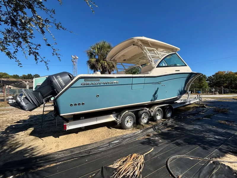 Slide: The Image of 2019 Grady-White Freedom 375 boat on trailer, parked outdoors under clear blue sky. - 2