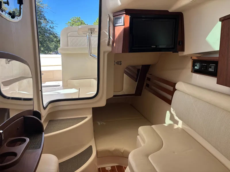 Slide: The Image of 2019 Grady-White Freedom 375 cabin interior with seating, TV, and wood accents. - 26
