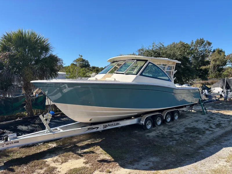 Slide: The Image of 2019 Grady-White Freedom 375 boat on trailer, parked outdoors under clear blue sky. - 3