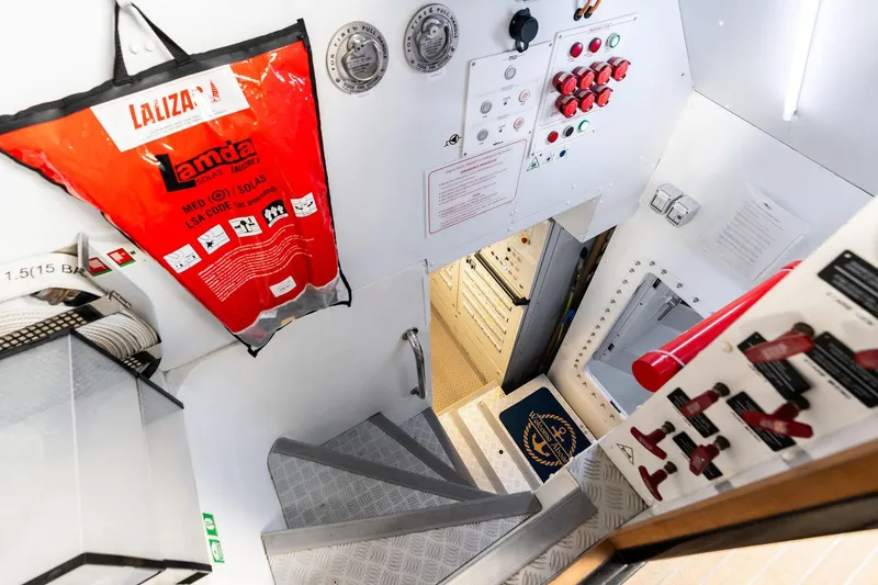 Slide: The Image of Engine room entrance of 2025 Riva 130' Bellissima yacht with safety equipment and control panels. - 99
