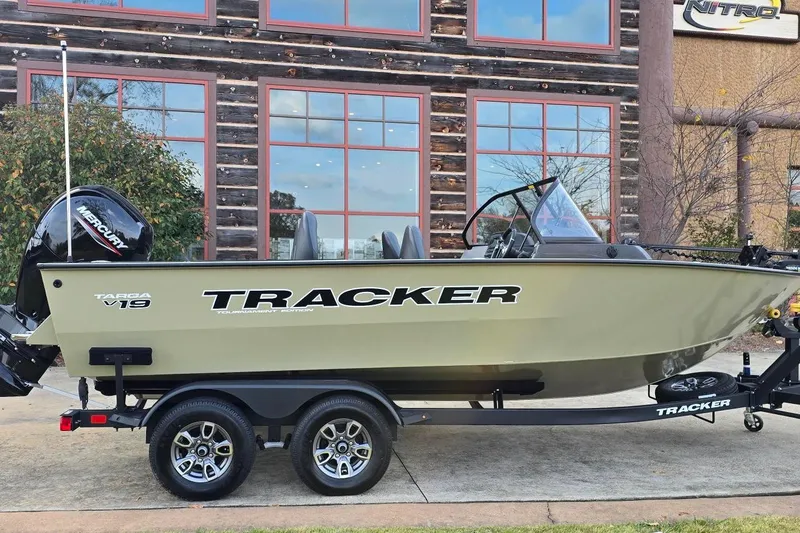 The Image of 2026 Tracker Targa V-19 Combo boat on trailer, parked outside a rustic building. - 0