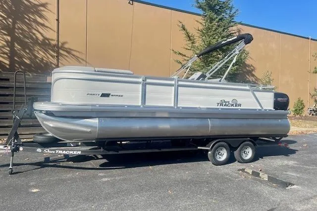 Slide: The Image of 2026 Sun Tracker Party Barge 22 RF DLX pontoon boat on trailer, parked outdoors. - 9
