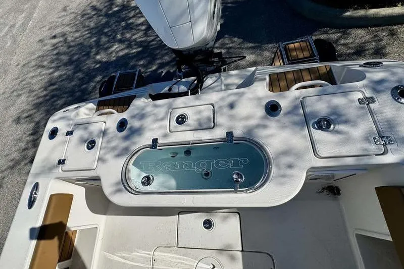 Slide: The Image of 2026 Ranger 2600 Bay boat deck with storage compartments and motor. - 13