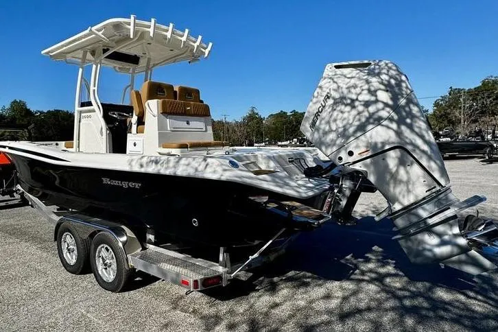 Slide: The Image of 2026 Ranger 2600 Bay boat on trailer with powerful outboard motor, parked outdoors. - 7
