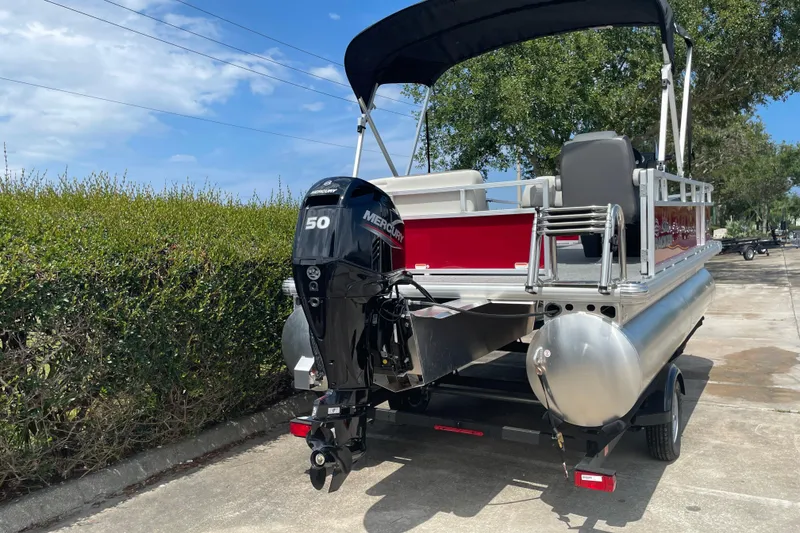 Slide: The Image of 2026 Sun Tracker Bass Buggy 16 XL Select pontoon boat with Mercury 50 engine, parked outdoors. - 6