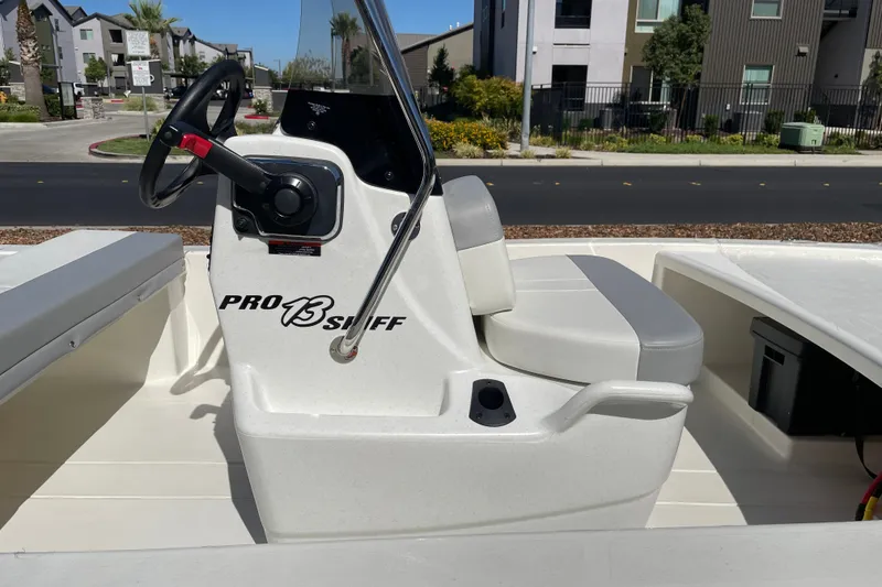 Slide: The Image of 2026 Mako Pro Skiff 13 CC boat interior with steering console and seating. - 6