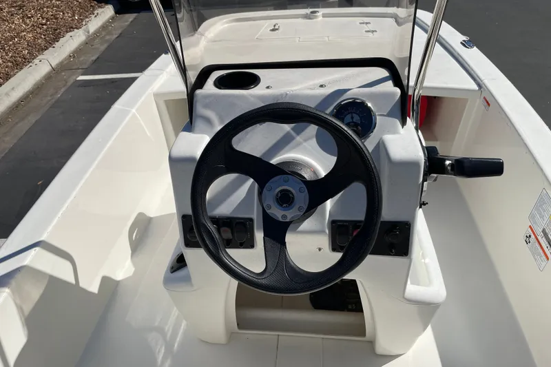 Slide: The Image of 2026 Mako Pro Skiff 13 CC boat console with steering wheel and controls. - 8