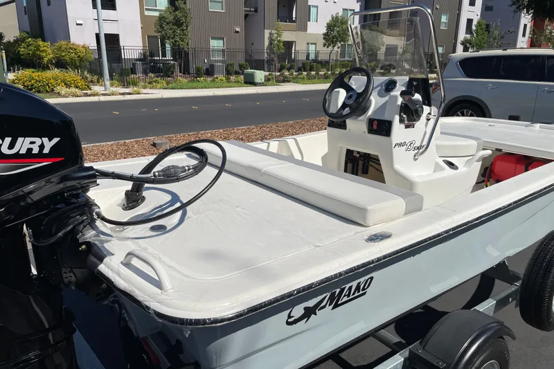 Slide: The Image of 2026 Mako Pro Skiff 13 CC boat with Mercury engine, parked on a trailer. - 4