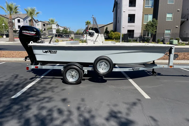The Image of 2026 Mako Pro Skiff 13 CC boat on trailer, parked in urban setting. - 0