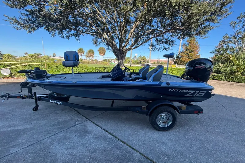 The Image of 2026 Nitro Z18 Pro fishing boat on trailer, parked outdoors under a tree. - 0
