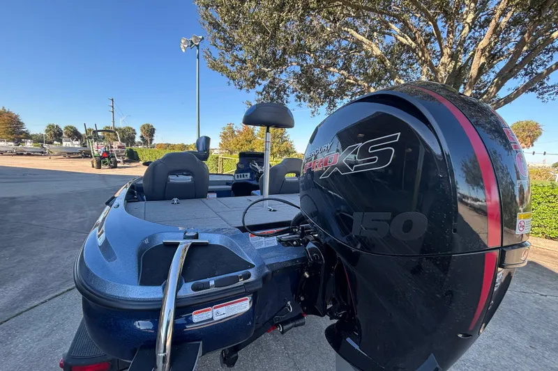 Slide: The Image of 2026 Nitro Z18 Pro boat with Mercury Pro XS 150 engine, parked outdoors. - 2