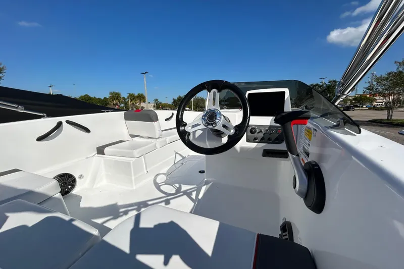 Slide: The Image of 2026 Tahoe T18 boat interior with steering wheel, seating, and control panel under clear blue sky. - 3