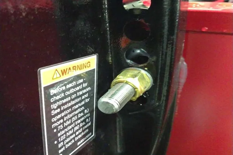 Slide: The Image of Close-up of a bolt with a warning label on a 2026 Tracker Pro Guide V-175 Combo. - 69