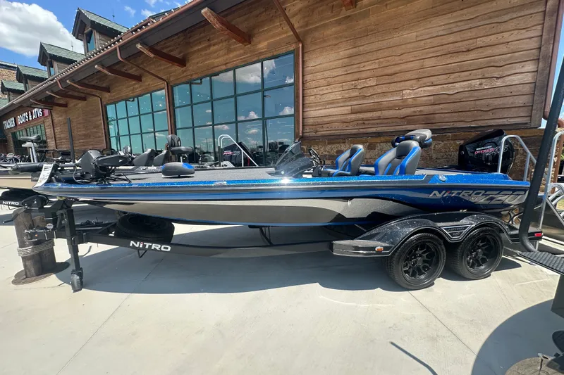 The Image of 2026 Nitro Z20 XL Pro boat displayed outside a wooden building. - 0