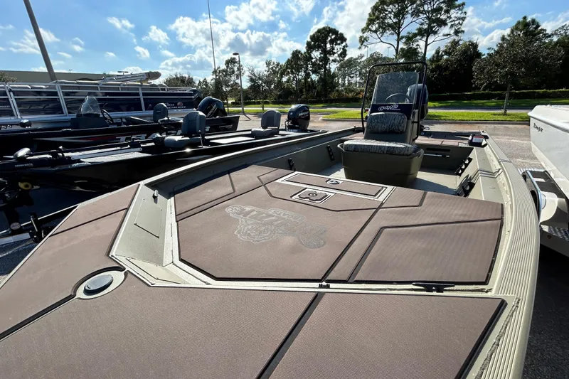 Slide: The Image of 2026 Tracker Grizzly 1860 CC boat with spacious deck and seating, parked outdoors. - 2