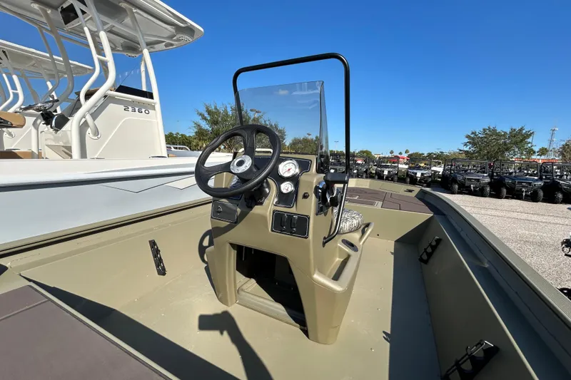 Slide: The Image of 2026 Tracker Grizzly 1860 CC boat console with steering wheel and gauges under clear blue sky. - 5