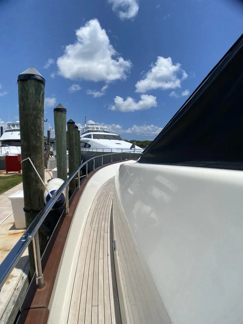 Slide: The Image of Deck of 1999 Azimut 85 Ultimate yacht with wooden flooring and marina view. - 100