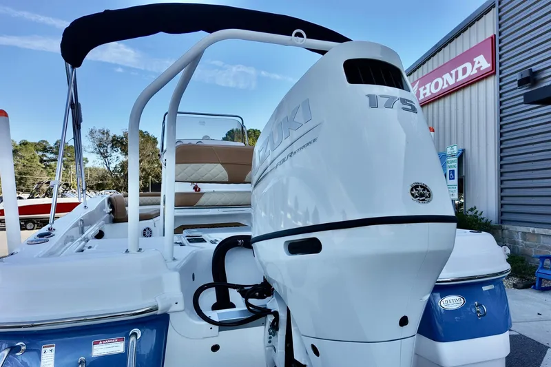 Slide: The Image of 2025 NauticStar 211 Hybrid boat with Suzuki 175 engine, displayed near a Honda dealership. - 11