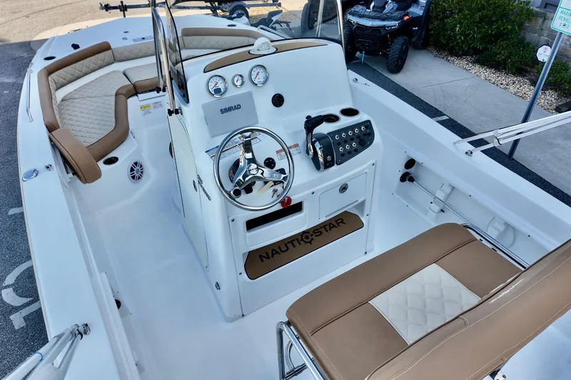 Slide: The Image of 2025 NauticStar 211 Hybrid boat interior with steering console and cushioned seating. - 12