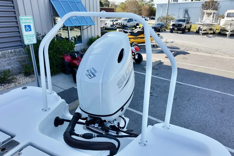 Slide: The Image of 2025 NauticStar 211 Hybrid boat with Suzuki outboard motor in parking lot. - 13