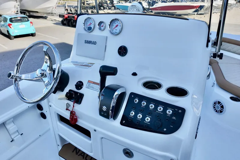 Slide: The Image of 2025 NauticStar 211 Hybrid boat console with steering wheel, gauges, and controls. - 18