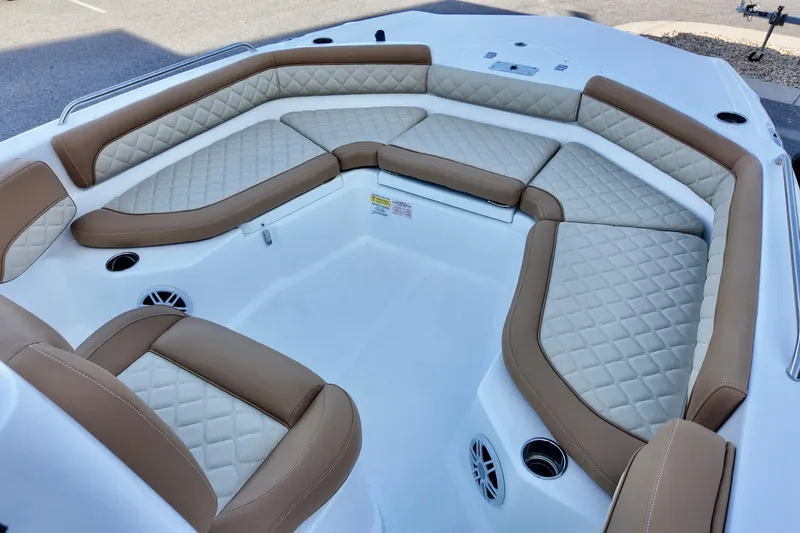Slide: The Image of 2025 NauticStar 211 Hybrid boat interior with tan and cream cushioned seating. - 21