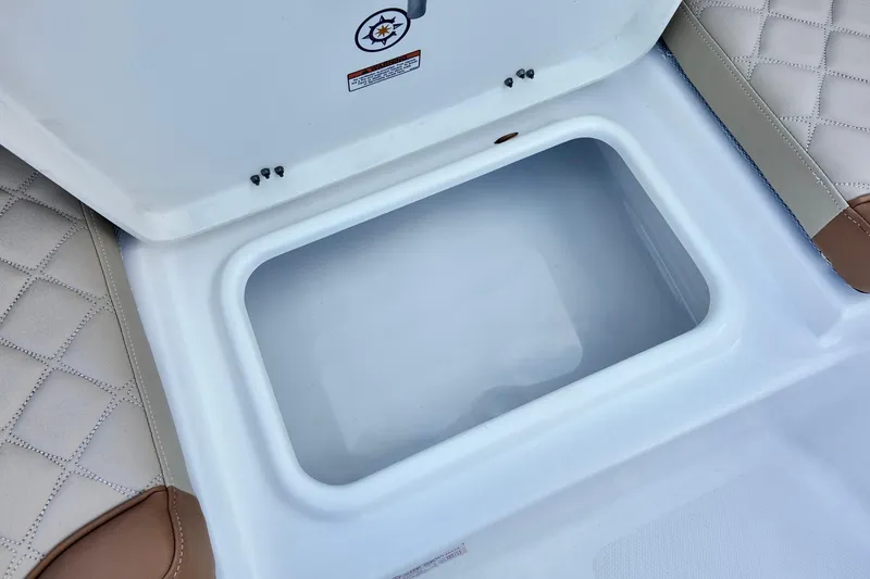 Slide: The Image of Open storage compartment on 2025 NauticStar 211 Hybrid boat, featuring quilted seating. - 7