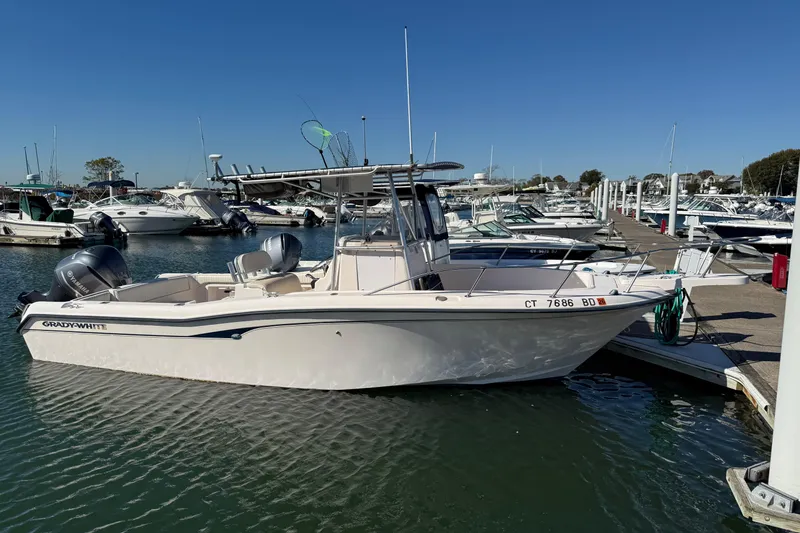 The Image of 1998 Grady-White Advance 247 boat docked in marina, clear blue sky background. - 1