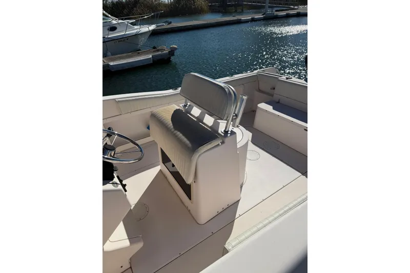 Slide: The Image of 1998 Grady-White Advance 247 boat interior with seating and steering wheel, docked by water. - 10
