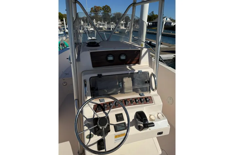 Slide: The Image of 1998 Grady-White Advance 247 boat console with steering wheel and controls at marina. - 13
