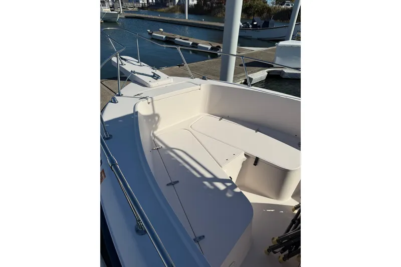 Slide: The Image of 1998 Grady-White Advance 247 boat interior at dock, showcasing seating and deck layout. - 3